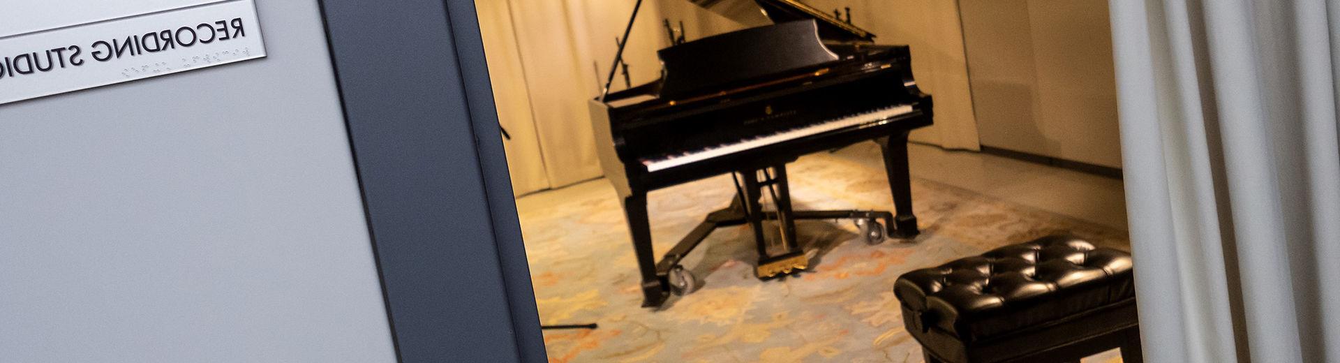 Practice room in music school with a gr和 piano 和 blue patterned carpet